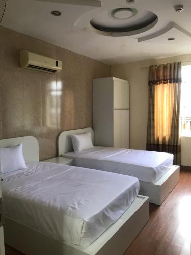two beds in a room with two bedsitures at Queenie Hotel 2 in Hai Phong
