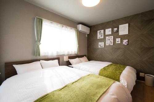 two beds sitting next to each other in a room at 巡り宿丸亀-最大9名 in Marugame