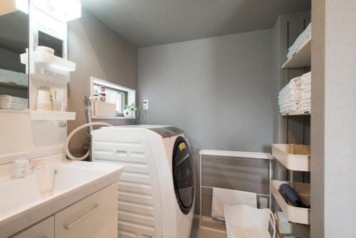 a kitchen with a white refrigerator in a room at 巡り宿丸亀-最大9名 in Marugame