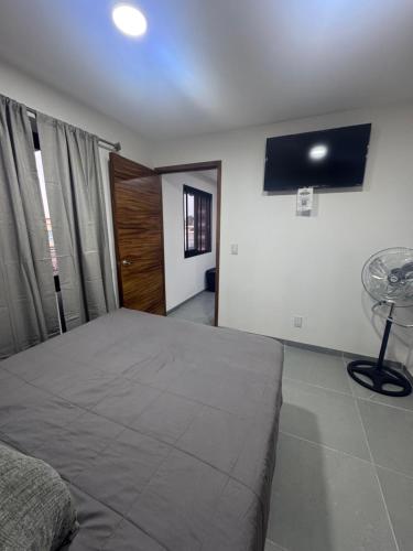 a bedroom with a bed and a tv on the wall at Modernos Departamentos Centricos in Ciudad Guzmán