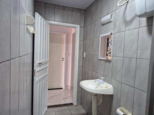 a bathroom with a sink and a mirror at Quarto casal Nereidas bwc compartilhado in Guaratuba