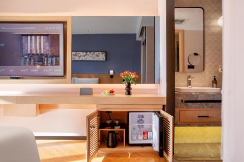 a room with a kitchen with a sink and a desk at Orange Crystal Hotel Dali Erhai Park in Dali