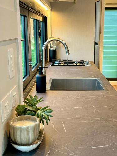 a kitchen counter top with a sink and a sink at Cape Byron Cabin in Coorabell Creek