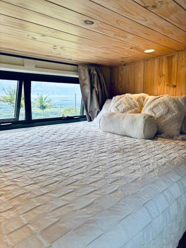 a large bed in a room with a wooden ceiling at Cape Byron Cabin in Coorabell Creek