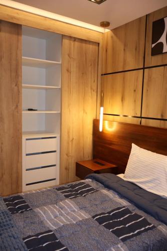 a bedroom with a bed and a wooden wall at Ramon Luxury Suites in Gualaceo