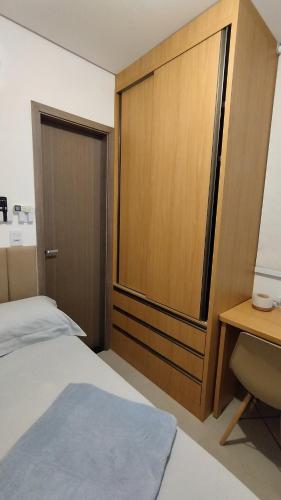 a bedroom with a bed and a wooden door at Studio moderno e bem localizado in João Monlevade