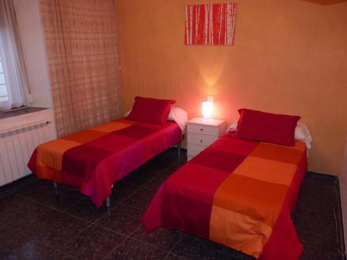 アルカラ・デル・フカルにあるCasa Rural El Jacuzziのベッド2台が隣同士に設置された部屋です。