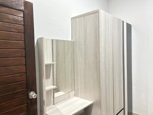 a bathroom with a mirror and a wooden door at Family house villa in Ban Rai Yai