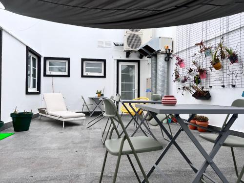 a living room with a table and chairs at Portas Residence, Quartos & Suites - Ponta Delgada City Center in Ponta Delgada