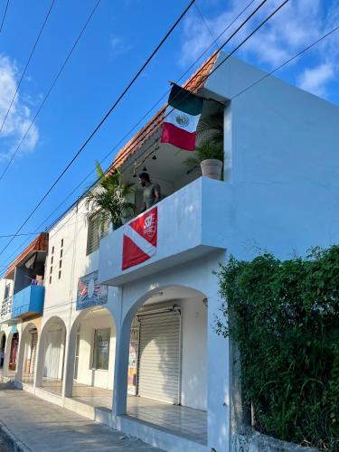 a white building with flags on top of it at Mi Refugio Dive House in Cozumel