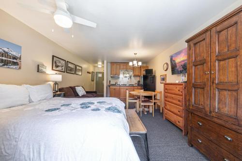 a bedroom with a large bed and a kitchen at Cozy Studio wKitchen #217 at Donner Lake Village in Truckee