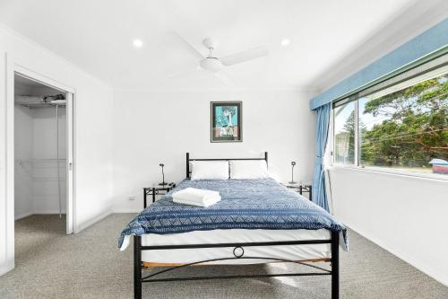 a bedroom with a bed and a window at Unit 8 Boardwalk Apartments in Narooma