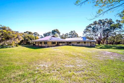 a large house with a large grassy field in front of it at Cockburn Airoprt 6BR Farmstay nr Fremantle&Beach in Perth