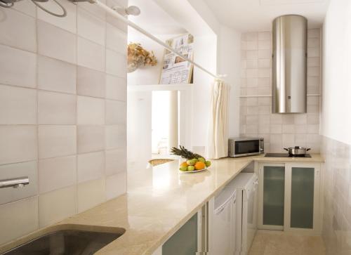 a kitchen with white tiled walls and a counter top at Apartamentos Alemanes Gradas Luxury in Seville