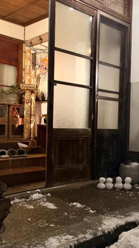 an open door in a room with snow on the ground at Guest House時音 in Joetsu