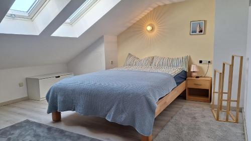 a bedroom with a bed with a blue comforter at Sunset Apartment in Grafenwöhr