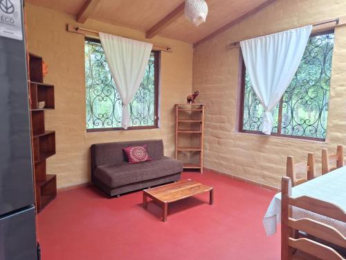 a living room with a couch and two windows at Casa Solomaco in Vilcabamba