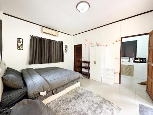 a living room with a couch and a clock on the wall at RJJhouse Kohphangan in Ban Nua