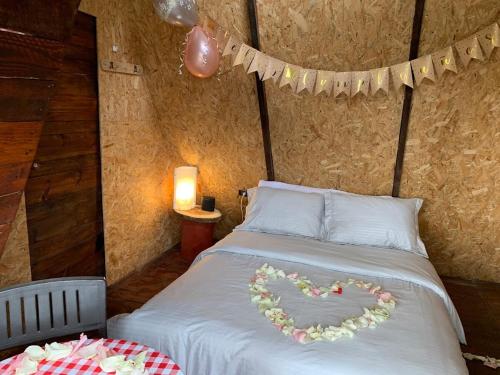 a bed with a heart made out of flowers on it at Nido Bag Glamping in Cali