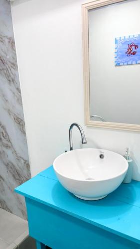 a white sink on a blue counter in a bathroom at Boho Pelicano in Bocas Town