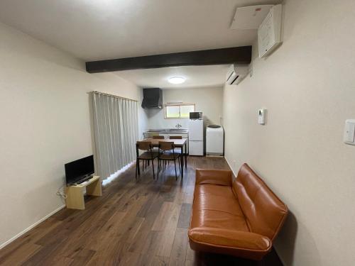 a living room with a leather couch and a table at 1棟貸切 連泊ok一日一組の宿ひめ in Kushimoto