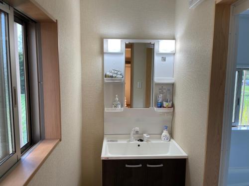 a bathroom with a sink and a mirror at 1棟貸切 連泊ok一日一組の宿ひめ in Kushimoto