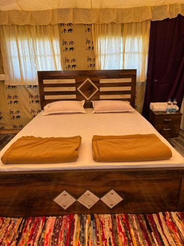 a bed with brown sheets and pillows on it at Aura Resort and Restaurant in Chikalthān