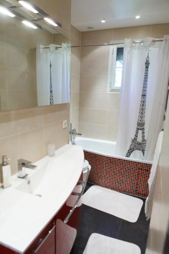 a bathroom with a sink and a tub with the eiffel tower at Villa Castoria in Saint-Germain-en-Laye