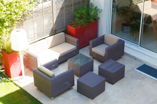 a group of chairs and ottomans on a patio at Villa Castoria in Saint-Germain-en-Laye