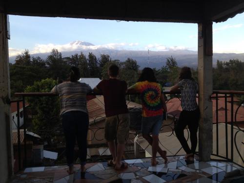 a group of people standing on a balcony looking at the view at Rafiki Backpackers & Guesthouse in Moshi