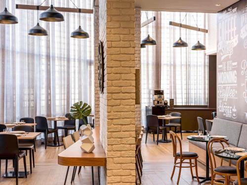 a restaurant with tables and chairs and windows at Mercure Sao Bernardo Do Campo in São Bernardo do Campo