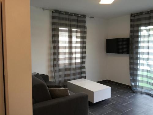 a living room with a couch and a coffee table at Hôtel Eden Cassis - centre-ville- piscine chauffée, jacuzzi et sauna - parking privé in Cassis