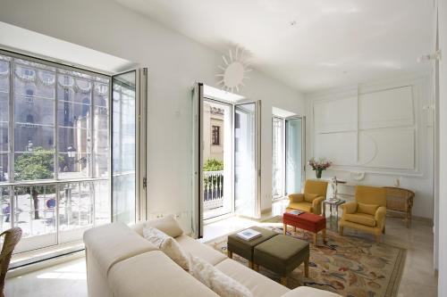 a living room with a white couch and windows at Apartamentos Alemanes Gradas Luxury in Seville