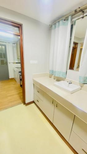 a bathroom with a sink and a mirror at Urban Host Buru Prime 1BR Luxe in Nairobi