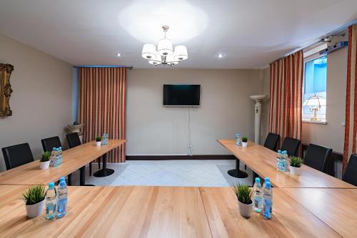 a conference room with tables and chairs and a television at Villa Sulejówek in Sulejówek