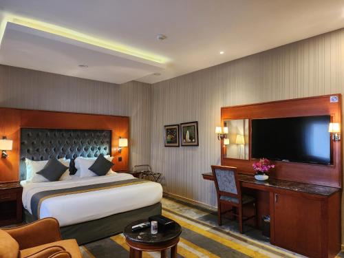 a hotel room with a bed and a flat screen tv at شاطئ الحياة للشقق المخدومة in Jeddah