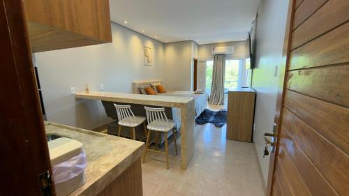 a kitchen with a counter and stools in a room at Flat 213 Ilha Bela Alter do Chão in Alter do Chao