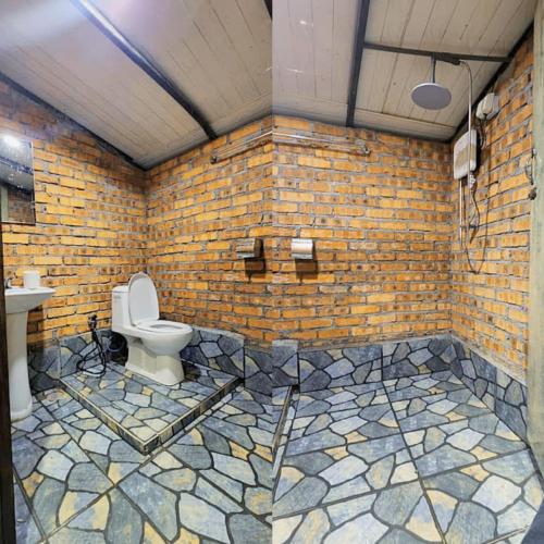 a brick bathroom with a toilet and a sink at Sameer Mountain View Glamping in Cameron Highlands