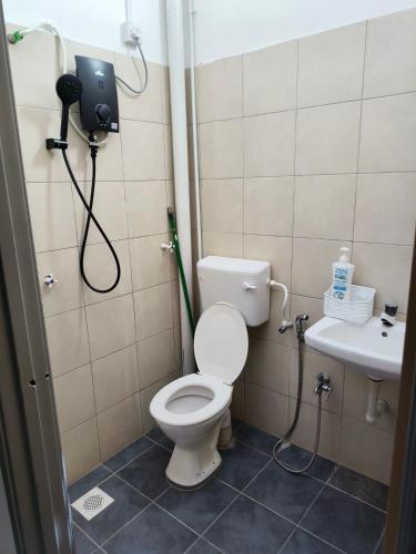 a bathroom with a toilet and a sink at Rumah SK in Batu Kurau