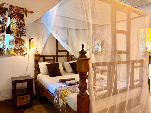a bedroom with a bed with a canopy at Casa Hera Diani in Diani Beach