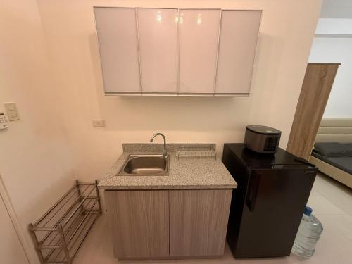 a small kitchen with a sink and a refrigerator at Minimalist Retreat in Minglanilla