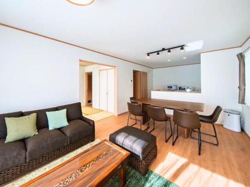 a living room with a couch and a table at Inamine Terrace in Nago