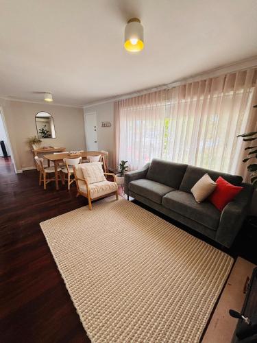 a living room with a couch and a table at Esperance Seaside Cottage in Esperance
