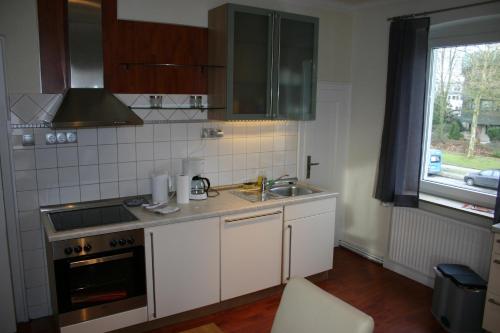 オスナブリュックにあるMinoの白いキャビネット、シンク、窓付きのキッチン
