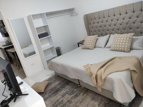 a bedroom with a bed and a desk with a television at Cozy Apartamento en Puebla! in San Baltasar