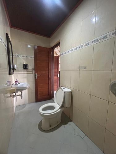 a bathroom with a toilet and a sink at Nami House in Ubud