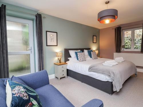 a bedroom with a bed and a couch and a window at Ferndale in Lynton