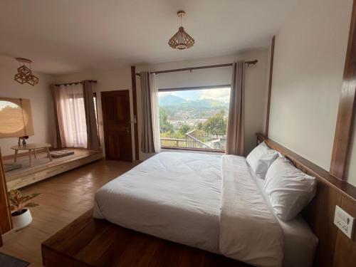 a bedroom with a bed and a large window at บ้านซินอัน in Ban Rak Thai