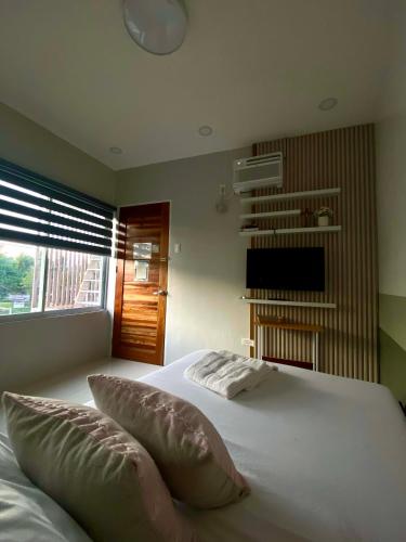 a bedroom with a large white bed with pillows at Lagkaw Ekonotel in Dipolog