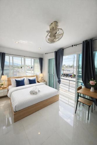 a bedroom with a large bed and a balcony at Leo Guest House in Khao Lak